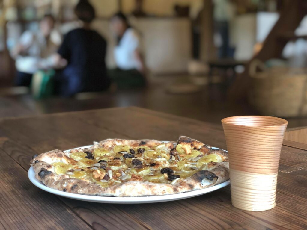 デザートピザと木のカップ
